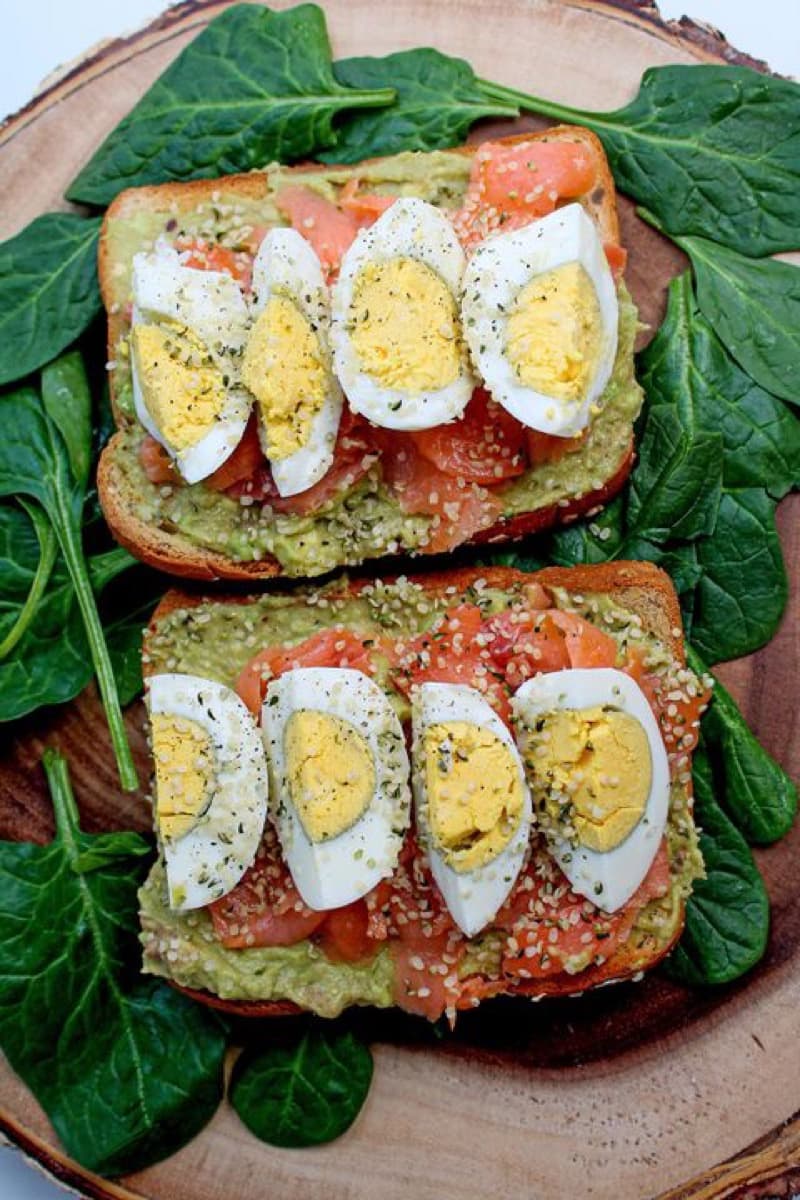 Smoked salmon toast with avocado and boiled egg on spinach