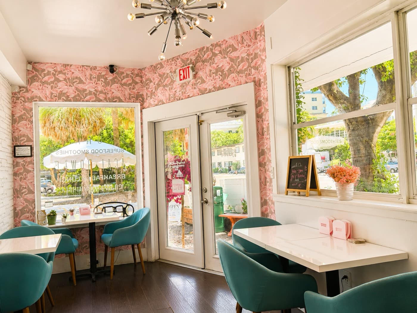 Inside the Grateful Juice shop, with flamingo wallpaper and teal cafe chairs
